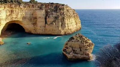 a large rock in the water next to a cave at Albufeira, Sea View (25) in Albufeira