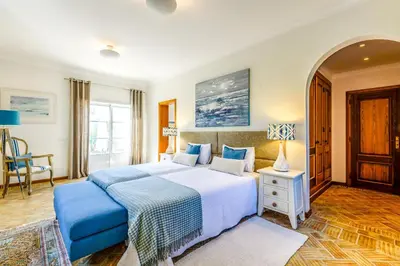 a bedroom with a large bed with blue pillows at Endless Summer Luxury Villa in Quinta do Lago