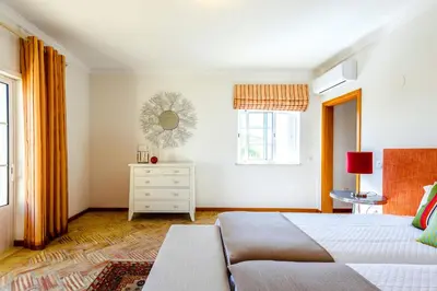 a bedroom with a bed and a dresser and a mirror at Endless Summer Luxury Villa in Quinta do Lago