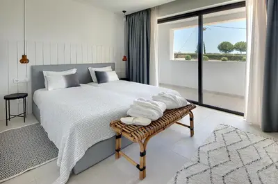 a bedroom with a large bed with towels on a bench at Villa Ocean Marina, Panoramic and heatable Pool by DreamvillasAlbufeira in Albufeira