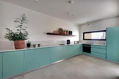 a kitchen with blue cabinets and a potted plant at Villa Ocean Marina, Panoramic and heatable Pool by DreamvillasAlbufeira in Albufeira