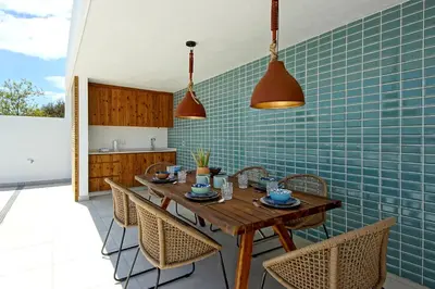 a kitchen with a wooden table and chairs at Villa Ocean Marina, Panoramic and heatable Pool by DreamvillasAlbufeira in Albufeira