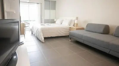 a bedroom with a bed and a couch and a tv at Aldeia do Mar Studio Vilamoura Center - SWIMMING POOL in Vilamoura