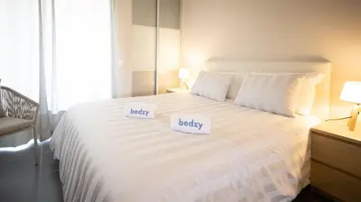 a bedroom with a large white bed with two white pillows at Aldeia do Mar Studio Vilamoura Center - SWIMMING POOL in Vilamoura