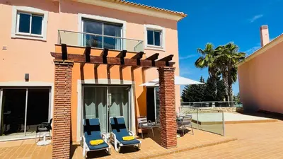 a house with two blue chairs on a patio at Santa Maria N by Check-in Portugal in Albufeira