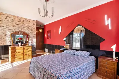 a bedroom with a bed and a red wall at Villa Calipso in Albufeira