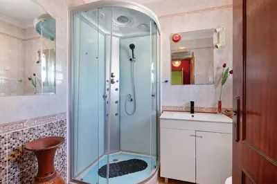 a glass shower in a bathroom with a sink at Villa Calipso in Albufeira