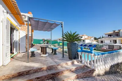 a patio with a table and chairs on a house at Villa Calipso in Albufeira