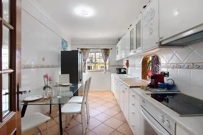 a kitchen with a counter and a table and chairs at Villa Calipso in Albufeira