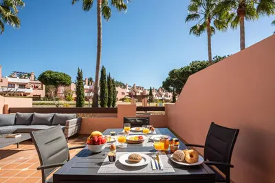a table with food and drinks on a balcony with palm trees at Villa Simone by Intiholidays in Quarteira