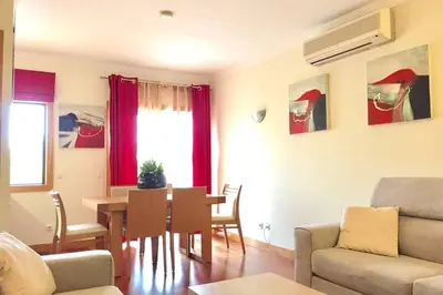 a living room with a table and a dining room at Albufeira parque da CORCOVADA standing flat W/Pool in Albufeira