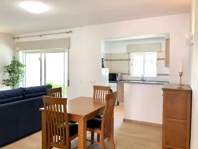 a living room with a blue couch and a wooden table at Albufeira + appartement proche plage avec piscine in Albufeira