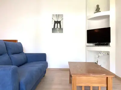 a living room with a blue couch and a table at Albufeira + appartement proche plage avec piscine in Albufeira