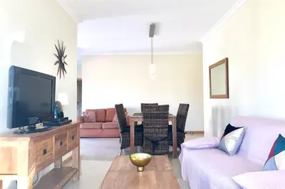 a living room with a couch and a tv at Albufeira l AMAZING terrasse with jacuzzi Encosta da Orada in Albufeira