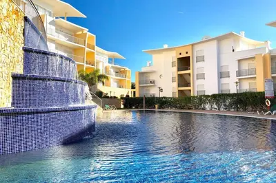 a swimming pool in front of some apartment buildings at Albufeira l AMAZING terrasse with jacuzzi Encosta da Orada in Albufeira