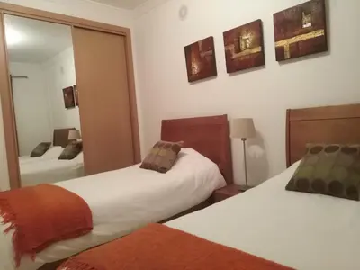 a bedroom with two beds and a mirror at Salgados Sea View Apartment in Albufeira