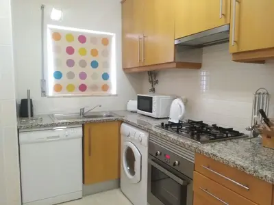 a kitchen with a stove and a sink and a microwave at Salgados Sea View Apartment in Albufeira