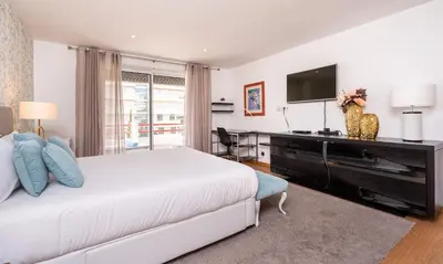 a bedroom with a bed and a desk and a television at Marina Luxor in Vilamoura
