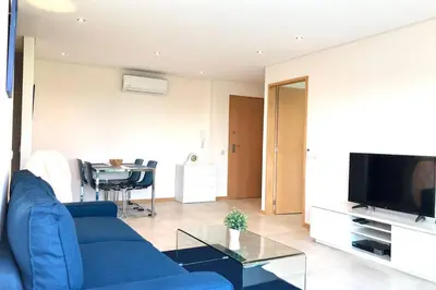 a living room with a blue couch and a television at Falesia beach l roof top pool in Albufeira