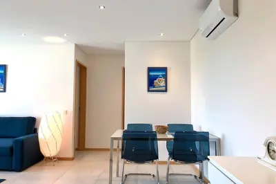 a dining room with a table and blue chairs at Falesia beach l roof top pool in Albufeira