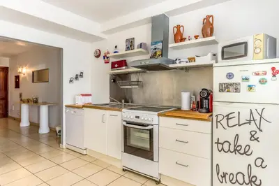 a kitchen with white cabinets and a stove top oven at FLH Albufeira Balcony Flat with Pool in Albufeira