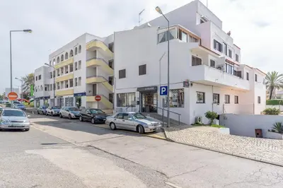 a street with cars parked in front of buildings at FLH Albufeira Balcony Flat with Pool in Albufeira