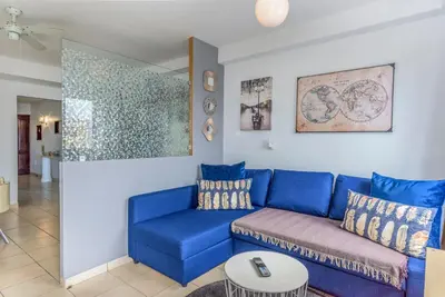a living room with a blue couch and a table at FLH Albufeira Balcony Flat with Pool in Albufeira