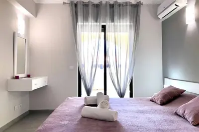 a bedroom with a large bed with a large window at Poente da Aldeia apartment in Albufeira