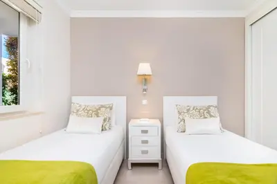 two beds in a small bedroom with a window at WHome | Prime Hideaway Luxury Villa in Quarteira