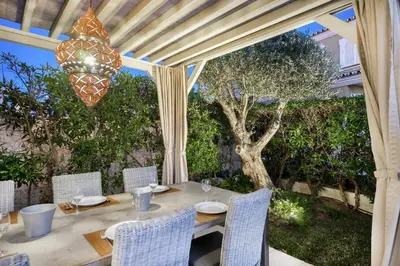 a wooden table with chairs and a chandelier at WHome | Prime Hideaway Luxury Villa in Quarteira