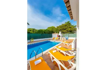 a swimming pool with orange lounge chairs and a swimming pool at VILLA COELHO in Albufeira