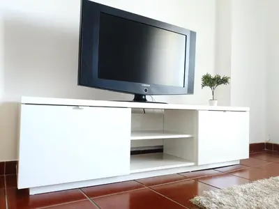 a flat screen tv on a white entertainment center at Pool and Garden Village-near beach in Albufeira