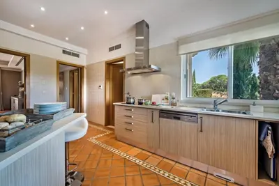 a kitchen with a sink and a large window at Villa Mayfair - Quinta do Lago in Almancil