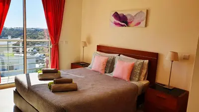 a bedroom with a large bed with a large window at Sunny Apartment with sea view in Albufeira in Albufeira