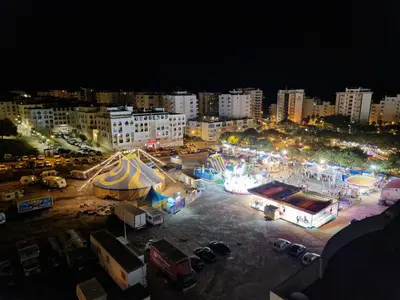 a city at night with a parking lot with tents at Apartamento Carvalhal in Quarteira