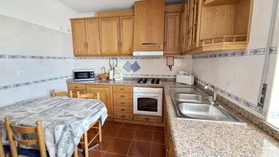 a small kitchen with a sink and a table at Apartamento Carvalhal in Quarteira