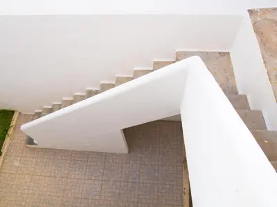 a white stair case with a white wall at Alagoa Terrace Guesthouse in Faro