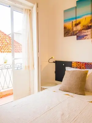 a bedroom with a bed and a large window at Alagoa Terrace Guesthouse in Faro