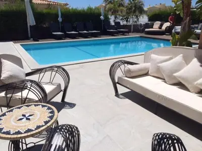 a patio with a couch and chairs next to a pool at Casa Corais in Guia