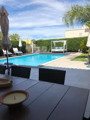 a pool with a table and chairs and an umbrella at Casa Corais in Guia