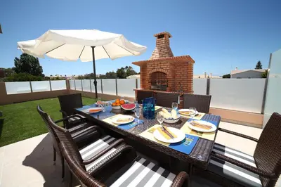a table with chairs and an umbrella on a patio at Casa Coralea in Guia