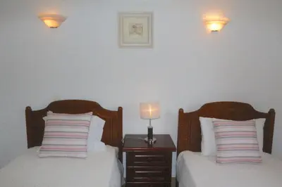 a bedroom with two beds and a night stand with a lamp at Vila Girasol, 171 - Clever Details in Vilamoura