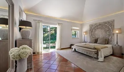 a large bedroom with a bed and a large window at Villa Gondra - Quinta do Lago - heated pool in Almancil
