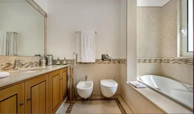 a bathroom with a tub and a toilet and a sink at Villa Gondra - Quinta do Lago - heated pool in Almancil