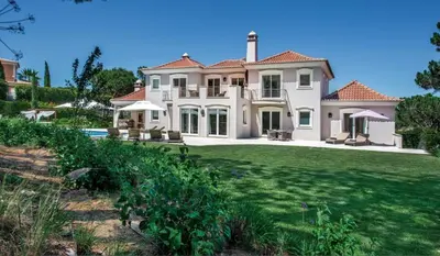 a large white house with a large yard at Villa Gondra - Quinta do Lago - heated pool in Almancil