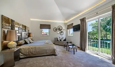 a bedroom with a large bed and a large window at Villa Gondra - Quinta do Lago - heated pool in Almancil
