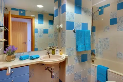 a bathroom with blue and white tiled walls and a sink at Marina Sand Residence in Albufeira