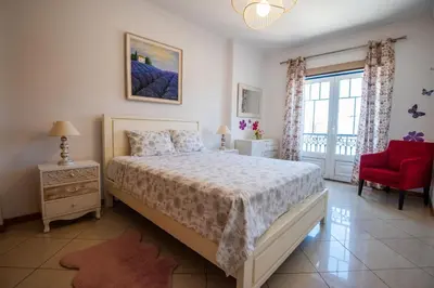 a bedroom with a bed and a red chair and a window at Charm Apartment T2 All With Big Terrace Albufeira Self check-in in Albufeira