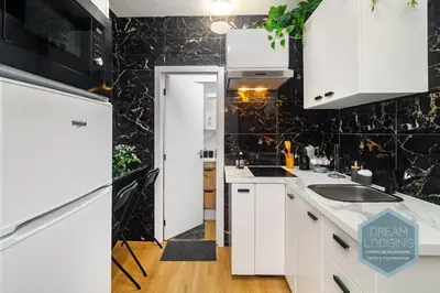 a kitchen with white cabinets and a black wall at Casa Branca 409 - Dream Lodging in Albufeira