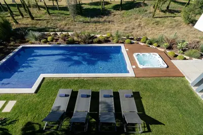 a swimming pool with lounge chairs next to a yard at Victoria Lux by SAPvillas in Vilamoura